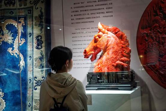 A person looking at a statue of a horseDescription generated with very high confidence