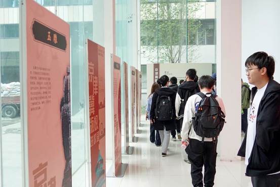 A group of people walking in a hallwayDescription generated with high confidence